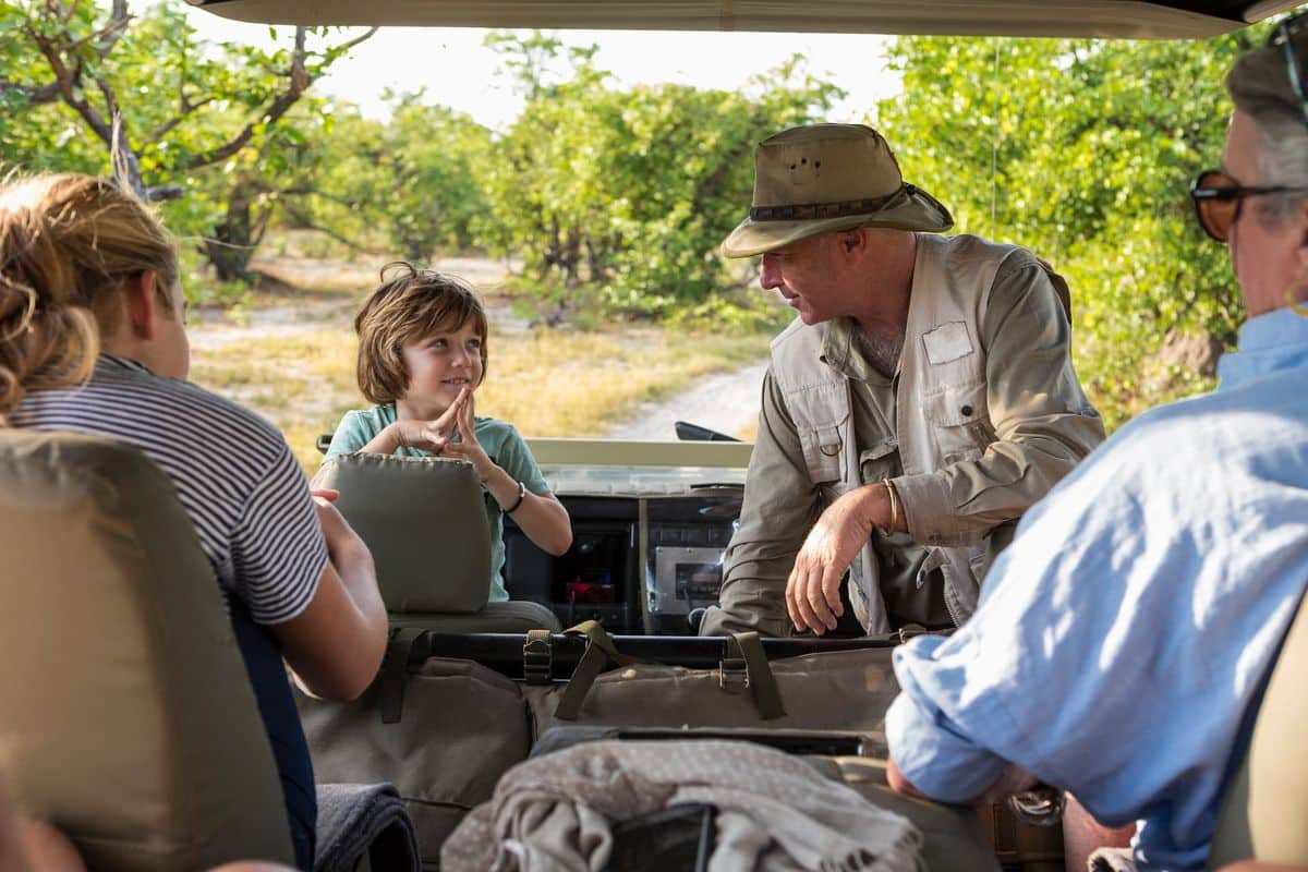 Un guide échange avec un groupe de voyageurs à bord d’un 4x4 de safari en Tanzanie
