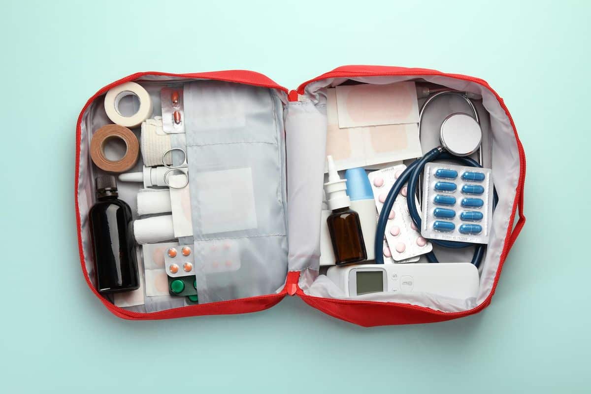 Trousse de premiers secours de voyage ouverte, médicaments et matériel rangés par compartiments